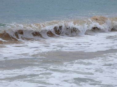 büyük dalgalar kum ve sahil kayalara çarpıyor