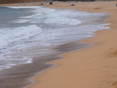 büyük dalgalar kum ve sahil kayalara çarpıyor