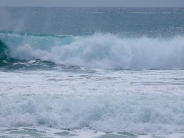 büyük dalgalar kum ve sahil kayalara çarpıyor