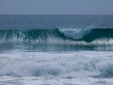 büyük dalgalar kum ve sahil kayalara çarpıyor
