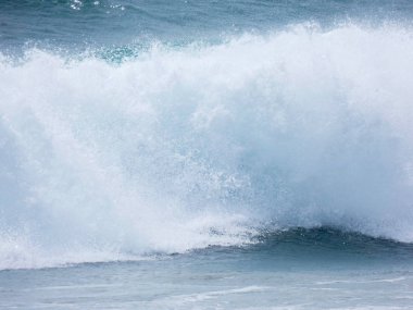 büyük dalgalar kum ve sahil kayalara çarpıyor