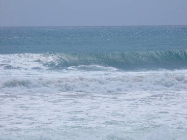büyük dalgalar kum ve sahil kayalara çarpıyor