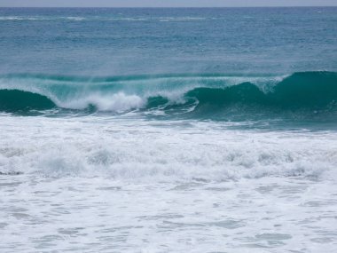 büyük dalgalar kum ve sahil kayalara çarpıyor