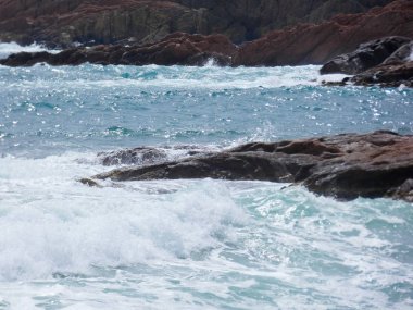 büyük dalgalar kum ve sahil kayalara çarpıyor