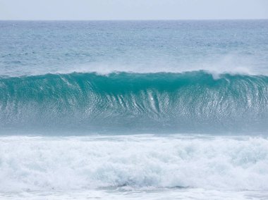 büyük dalgalar kum ve sahil kayalara çarpıyor