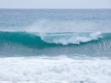 büyük dalgalar kum ve sahil kayalara çarpıyor