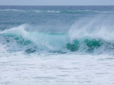 büyük dalgalar kum ve sahil kayalara çarpıyor