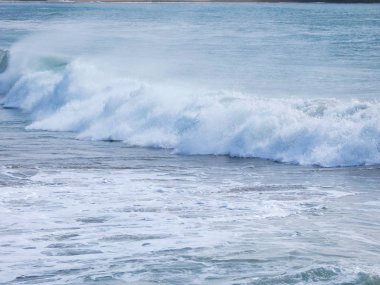 büyük dalgalar kum ve sahil kayalara çarpıyor