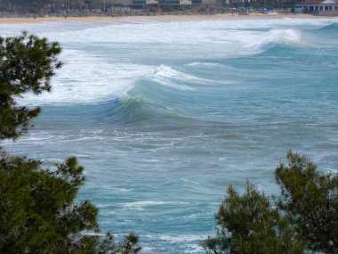 büyük dalgalar kum ve sahil kayalara çarpıyor
