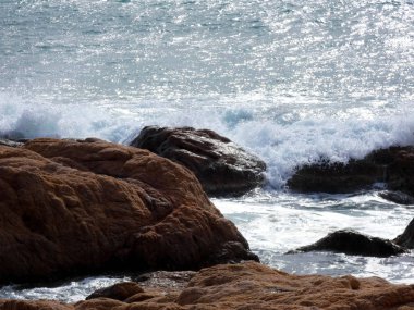 büyük dalgalar kum ve sahil kayalara çarpıyor