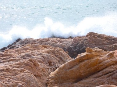 büyük dalgalar kum ve sahil kayalara çarpıyor