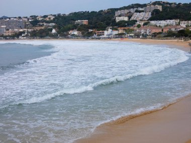 büyük dalgalar kum ve sahil kayalara çarpıyor