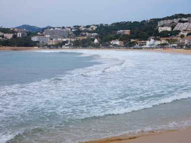 büyük dalgalar kum ve sahil kayalara çarpıyor