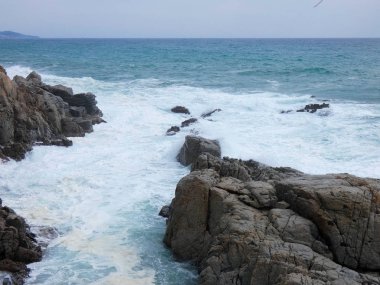 büyük dalgalar kum ve sahil kayalara çarpıyor