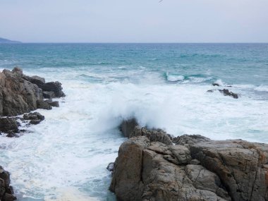 büyük dalgalar kum ve sahil kayalara çarpıyor