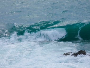 büyük dalgalar kum ve sahil kayalara çarpıyor