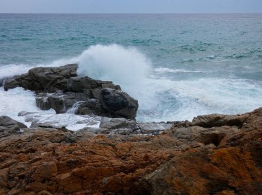 büyük dalgalar kum ve sahil kayalara çarpıyor