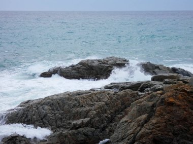 büyük dalgalar kum ve sahil kayalara çarpıyor