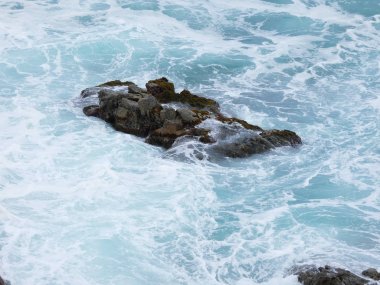 büyük dalgalar kum ve sahil kayalara çarpıyor
