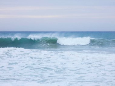 büyük dalgalar kum ve sahil kayalara çarpıyor