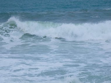 büyük dalgalar kum ve sahil kayalara çarpıyor