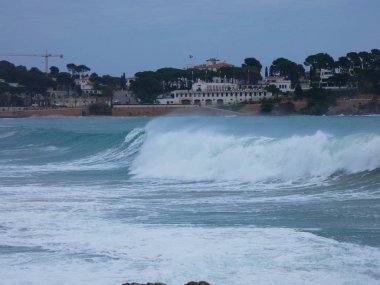 büyük dalgalar kum ve sahil kayalara çarpıyor