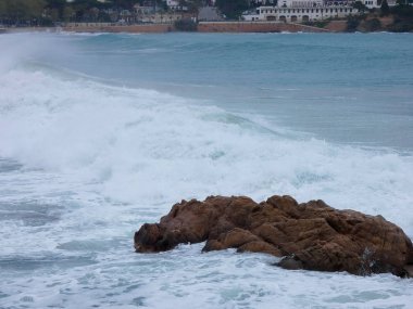 büyük dalgalar kum ve sahil kayalara çarpıyor