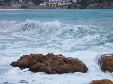büyük dalgalar kum ve sahil kayalara çarpıyor