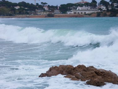 büyük dalgalar kum ve sahil kayalara çarpıyor