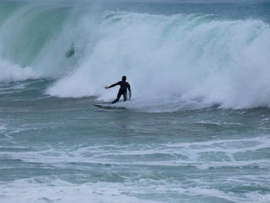 büyük dalgalar kum ve sahil kayalara çarpıyor