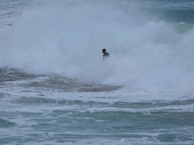 büyük dalgalar kum ve sahil kayalara çarpıyor