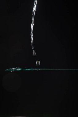 saydam bir cam üzerine düşen su