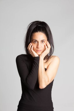 Genç kız elleriyle yüzünü çerçeveliyor.