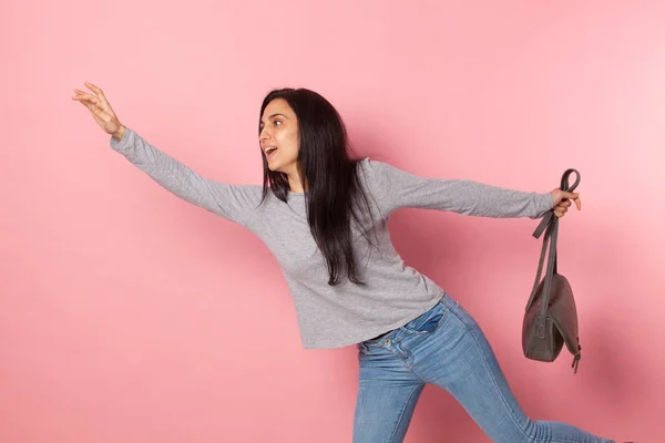 Young girl doing a dance step even though she seems to want to stop the bus