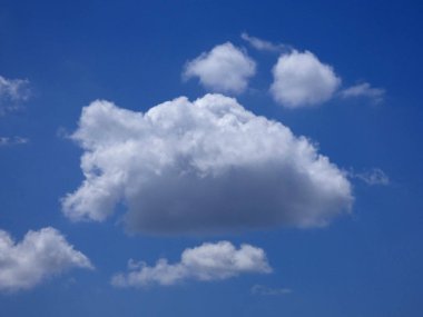 Mavi gökyüzünün üzerindeki bulutlar kaprisli şekiller oluşturuyor