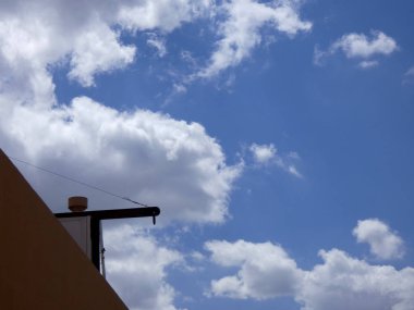 Mavi gökyüzünün üzerindeki bulutlar kaprisli şekiller oluşturuyor