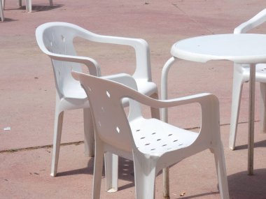Beyaz plastik masalar, sandalyeler, teraslar, bahçeler.