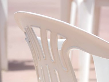 Beyaz plastik masalar, sandalyeler, teraslar, bahçeler.