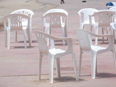 Beyaz plastik masalar, sandalyeler, teraslar, bahçeler.