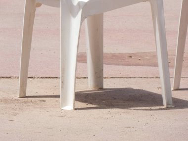 Beyaz plastik masalar, sandalyeler, teraslar, bahçeler.