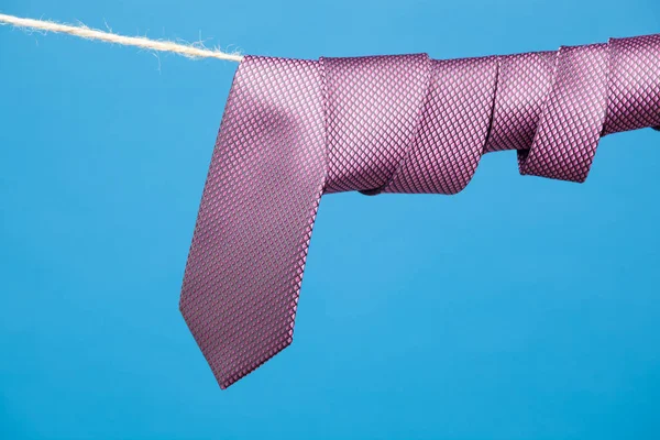 Tie is an element of the way of dressing of many professions, bankers, financiers, managers, executives, etc ... Tie knotted and hung from a rope held by clothespin. Classic way of dressing,