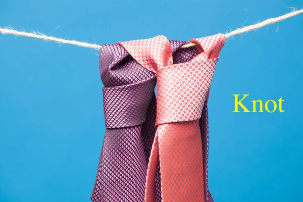 Tie with classic knot, hung on a rope and fastened by wooden clothespins to hang clothes