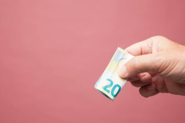 Elinde para, bir şey ödemek ya da satın almak için eylem, bir yatırımın yararları. Pazarda satın al. Rüşvet. Yetişkin bir kişinin elinde yasal ihale Euro notları.