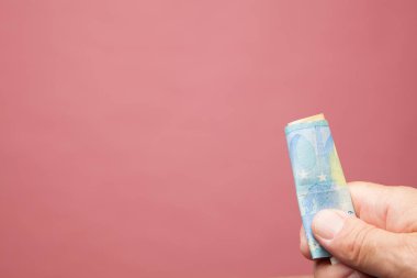 Elinde para, bir şey ödemek ya da satın almak için eylem, bir yatırımın yararları. Pazarda satın al. Rüşvet. Yetişkin bir kişinin elinde yasal ihale Euro notları.