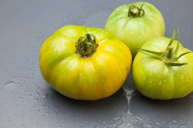 Domates kırmızı ve yeşil, organik, pazara bahçeden geldi. Kilometre sıfırın yakınlık ürünü, yakınlığın ürünü. Domates organik bir ürün olmak için lezzet ve vitamin dolu.