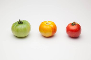 Domatesler yeşilden kırmızıya, olgunlaşma işlemi. Yeşil domates henüz tüketime hazır değil, kırmızı domates vitamin ve lezzet dolu, tüketim için hazırlanan.