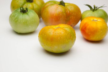 Domates kırmızı ve yeşil, organik, pazara bahçeden geldi. Kilometre sıfırın yakınlık ürünü, yakınlığın ürünü. Domates organik bir ürün olmak için lezzet ve vitamin dolu.