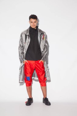 Fütüristik modern giysiler, beyaz arka plan üzerinde kentsel tasarımcı giysileri ile yakışıklı, seksi genç adam