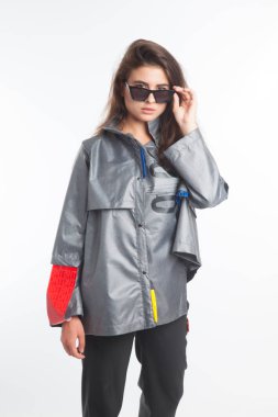 Güzel, seksi, şehvetli kız beyaz arka plan üzerinde fütüristik kentsel giysiler ile poz