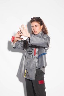 Genç kız saldırganlık ve korku ifadeleri ile modern ve tasarım bir şekilde giyinmiş. Çığlık atan kız